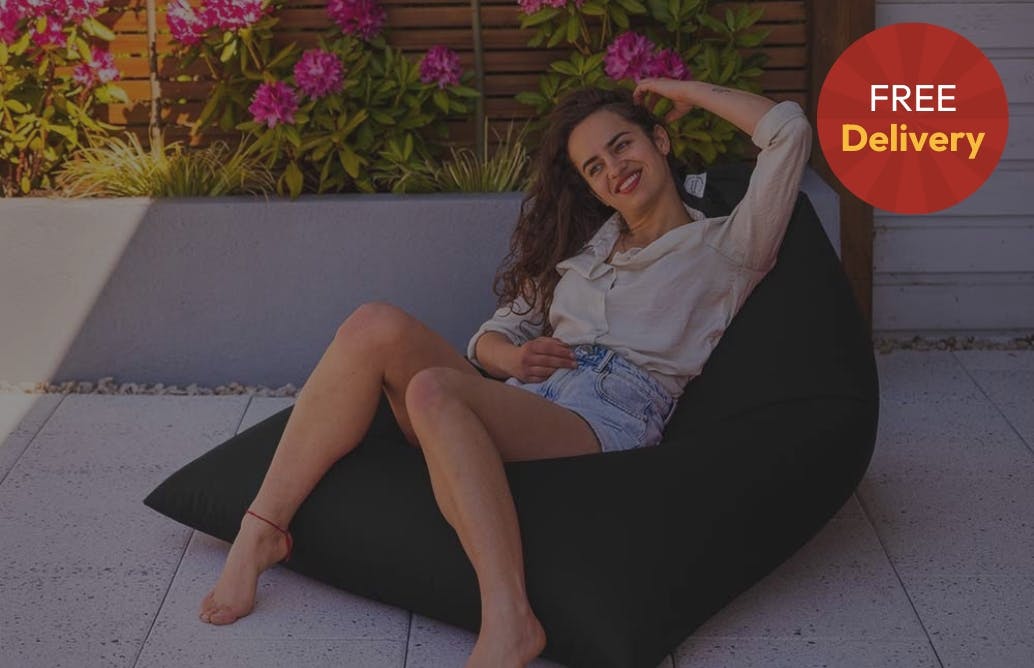 Girl sitting on outdoor beanbag in garden setting