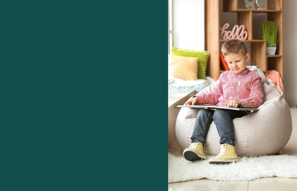 Little Boy Sitting on Beanbag Reading Book