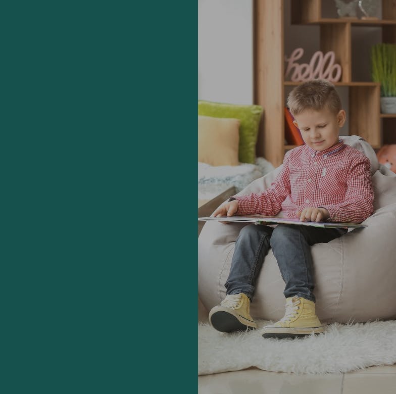 Little Boy Sitting on Beanbag Reading Book