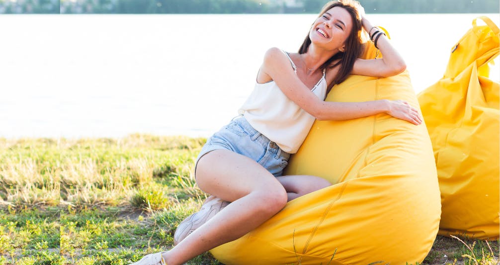 Woman on yellow beanbag outdoors