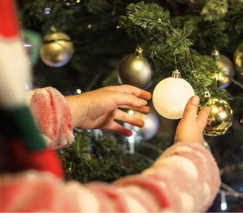 Decorating Artificial Christmas Tree with Christmas Baubles and Lights