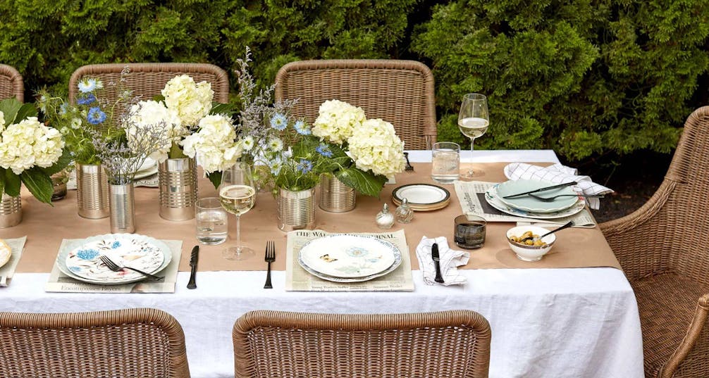 outdoor dining table setting with cream and blue flowers