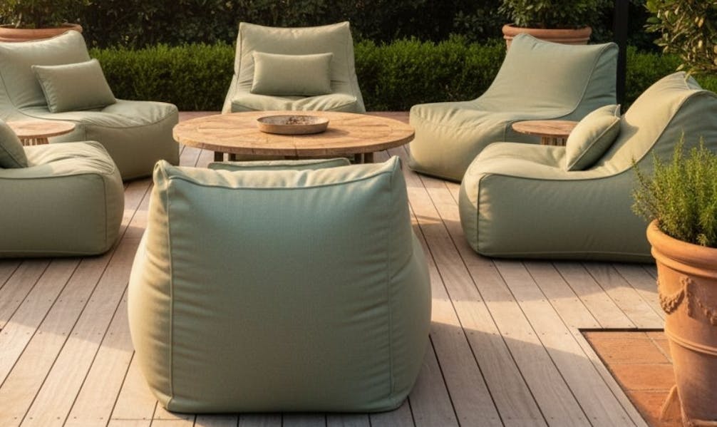 Sage green beanbags around a wooden table under an outdoor awning