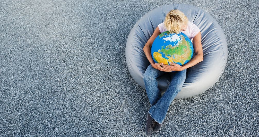 Person holding globe while sitting on beanbag