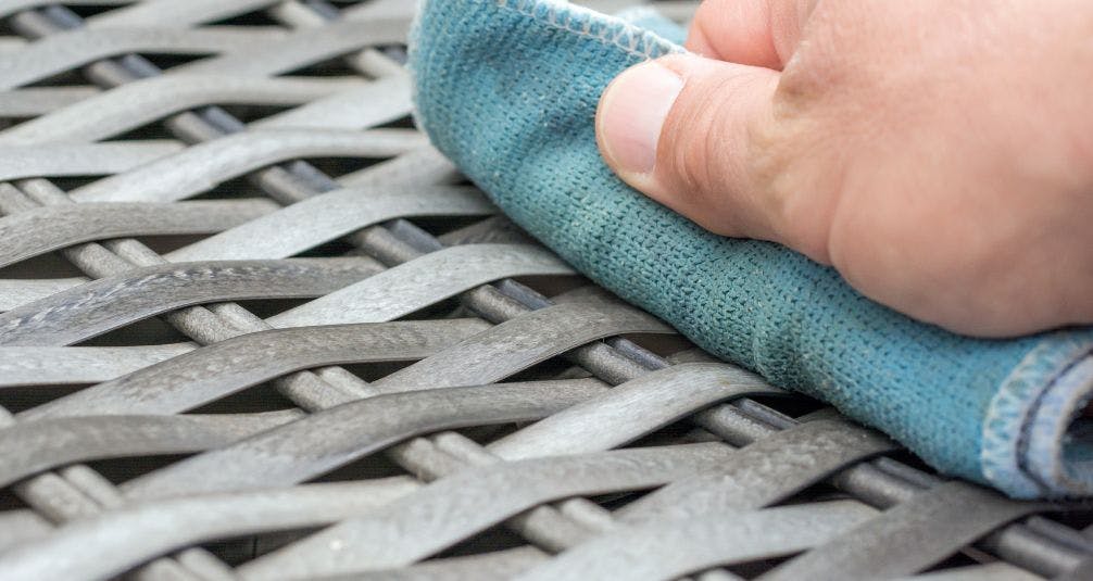 wiping down rattan furniture with cloth