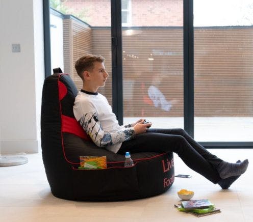 Boy sitting gaming on upright beanbag