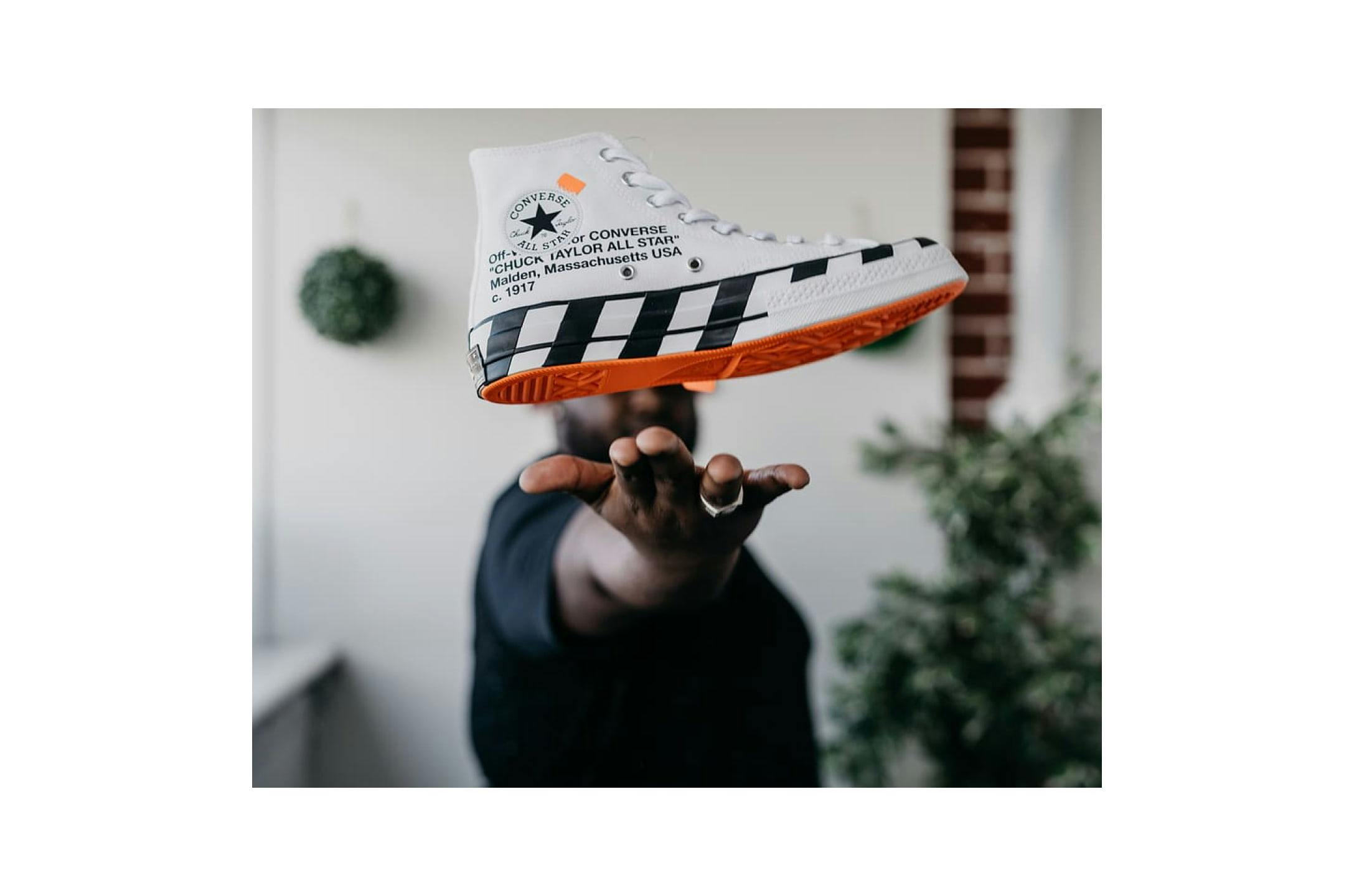 Man holding trendy sneaker in the palm of his hand