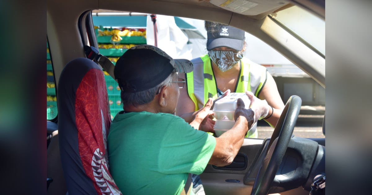 Photo of a man picking up food at a Hawai‘i Foodbank food distribution site