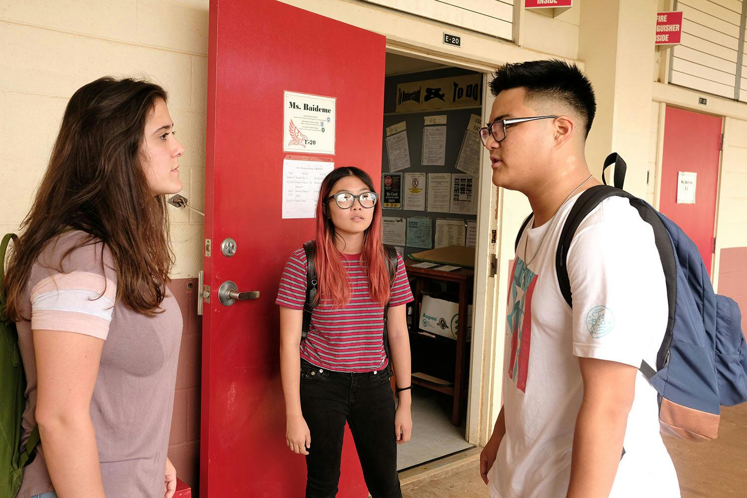 Photo of high school students having a difficult conversation in front of a classroom