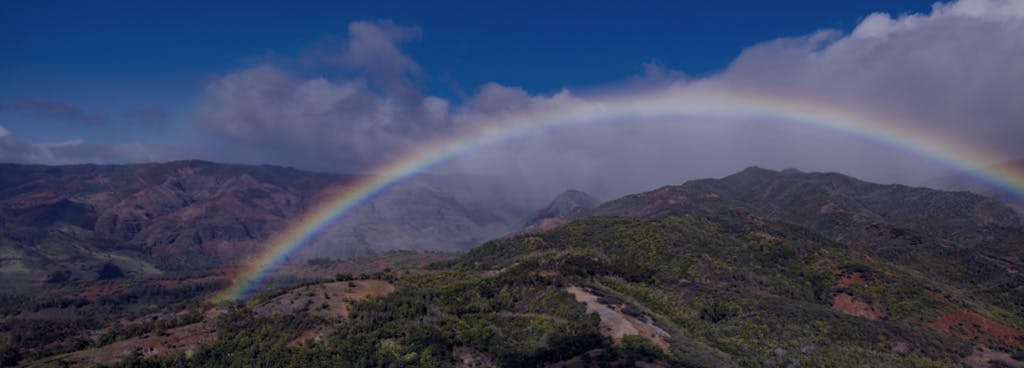 Photo of rainbow over mountains in Hawai‘i