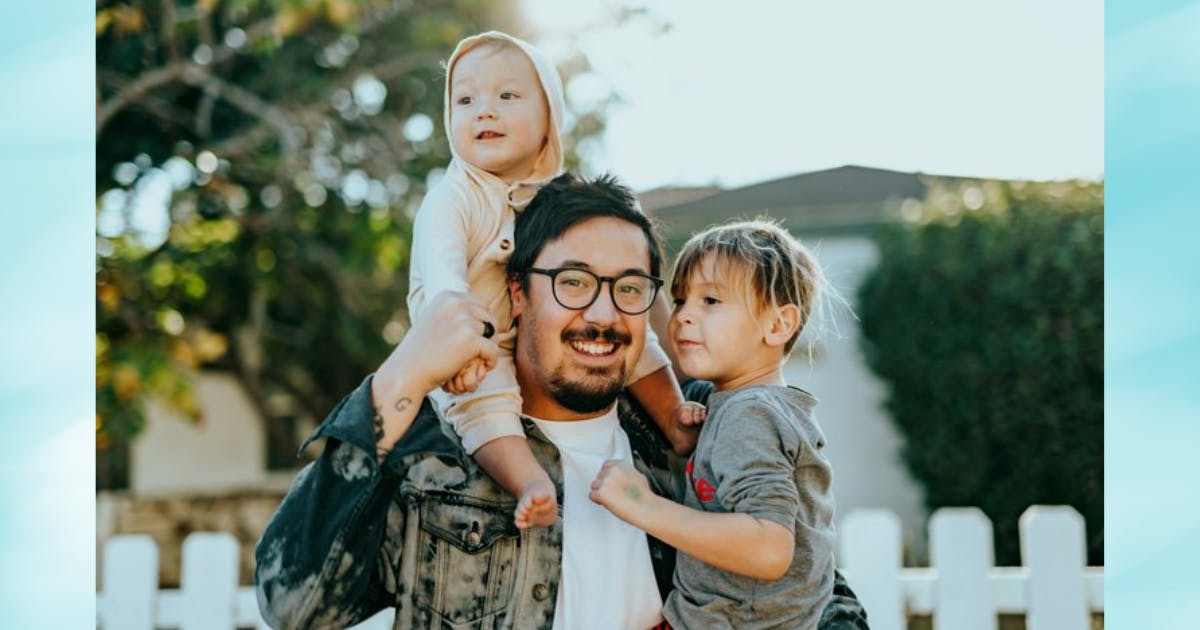 Photo of a dad and his two young children outside.