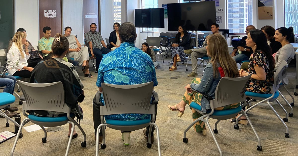 Photo of a large group of Fellows sitting in a circle and talking