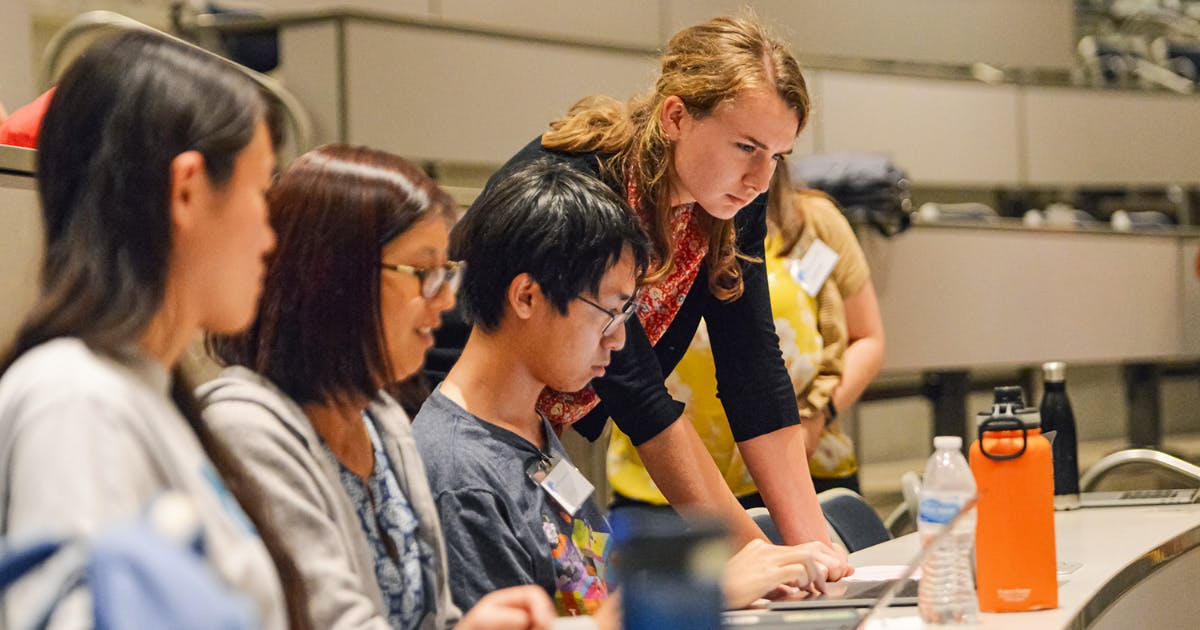 Photo of students developing an app on a laptop computer