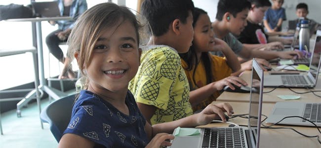 Photo of a group of young children using laptop computers