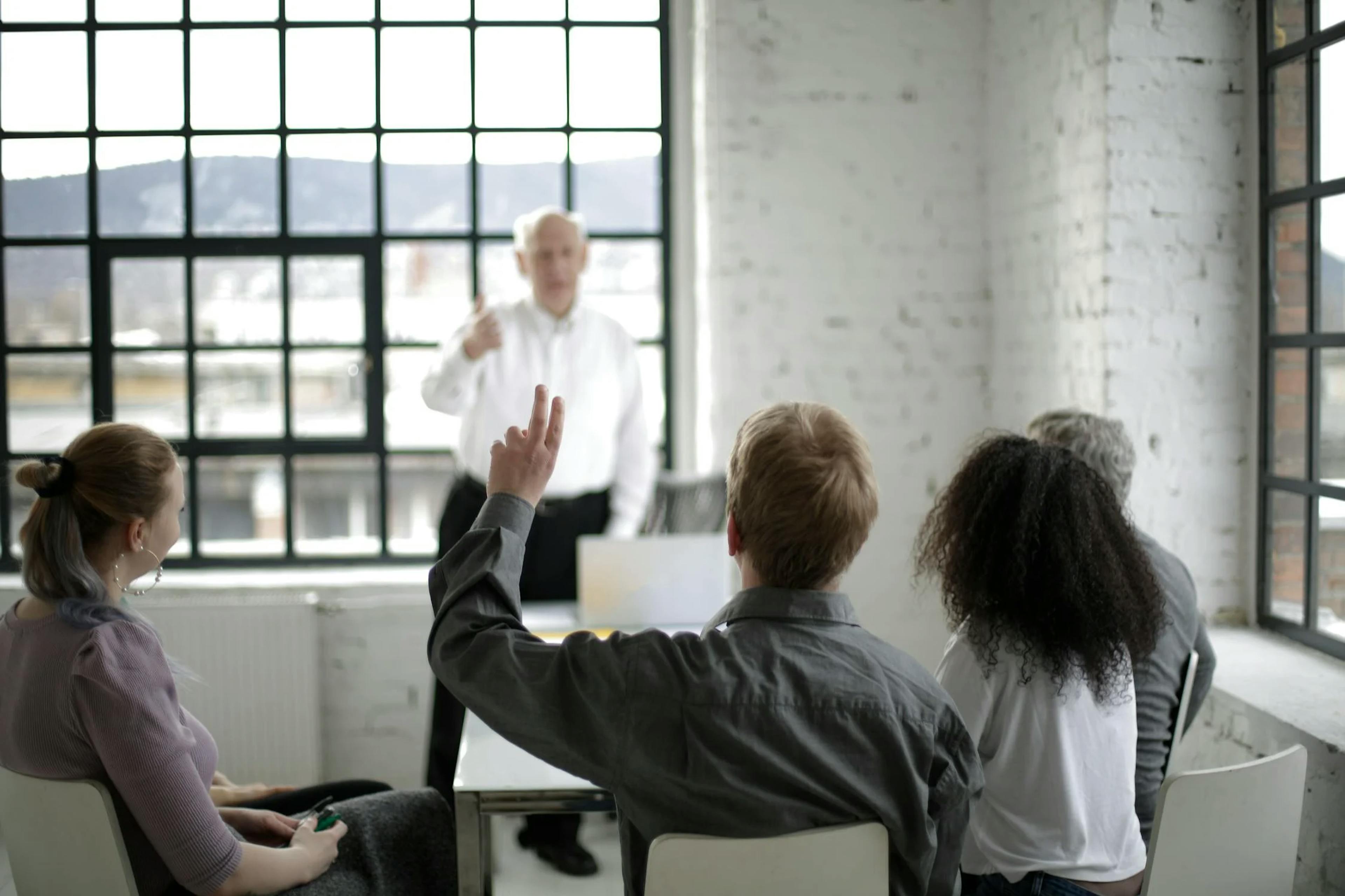 image showing a person raising his hand and asking a question