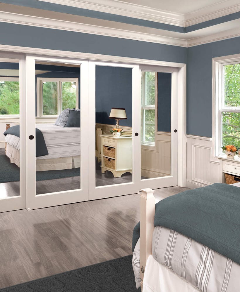 A four-panel closet in a blue bedroom.