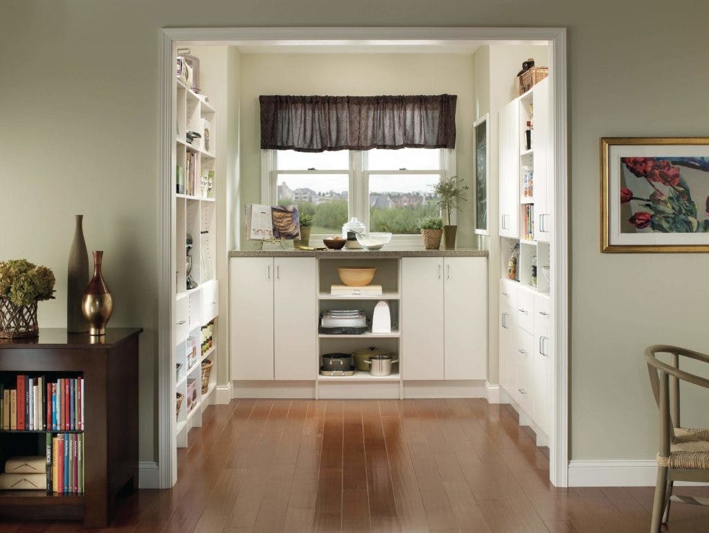 A white kitchen pantry with custom organizers. A white kitchen pantry with custom organizers.