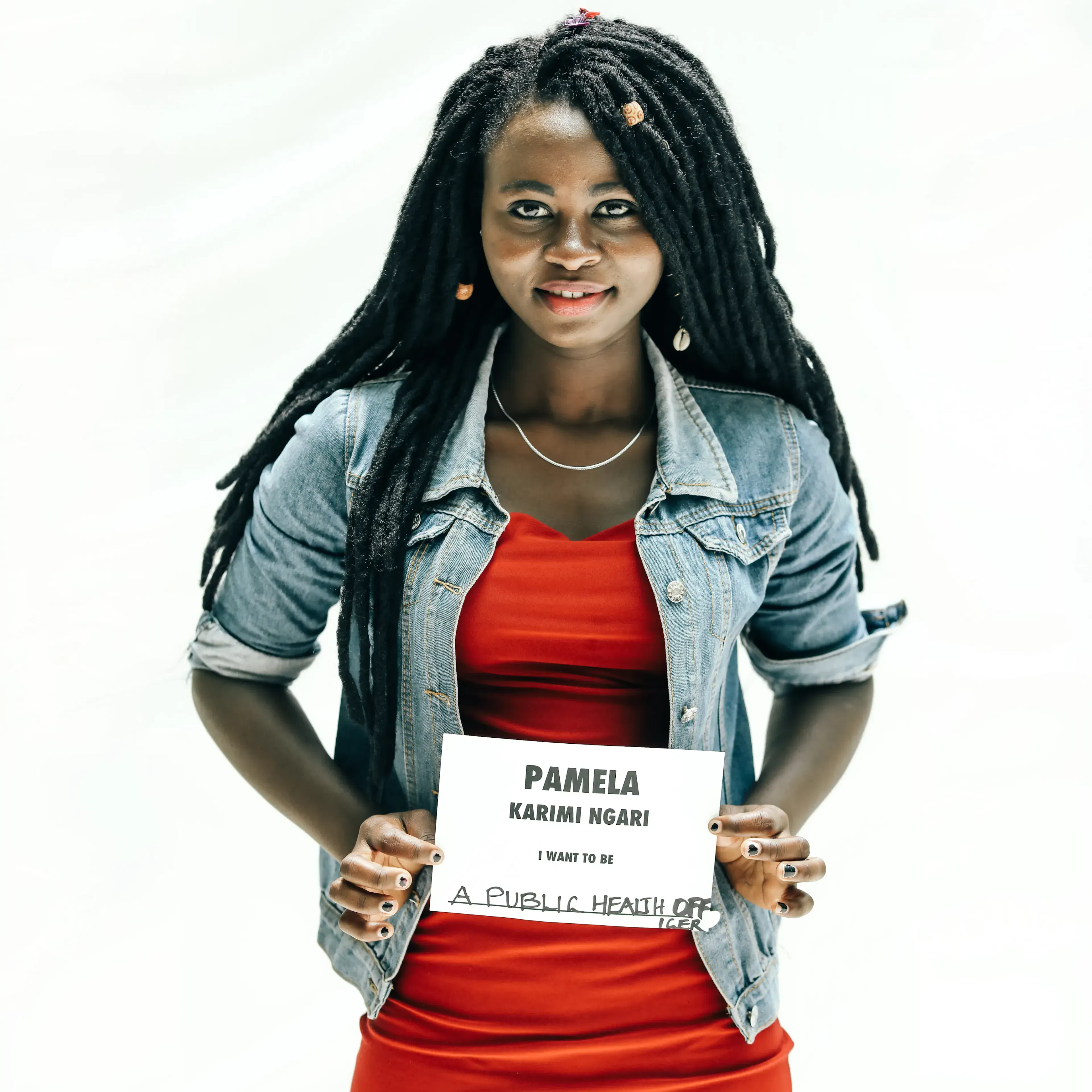 Pamela Karimi holding a sign reading 'I want to be a public health officer'