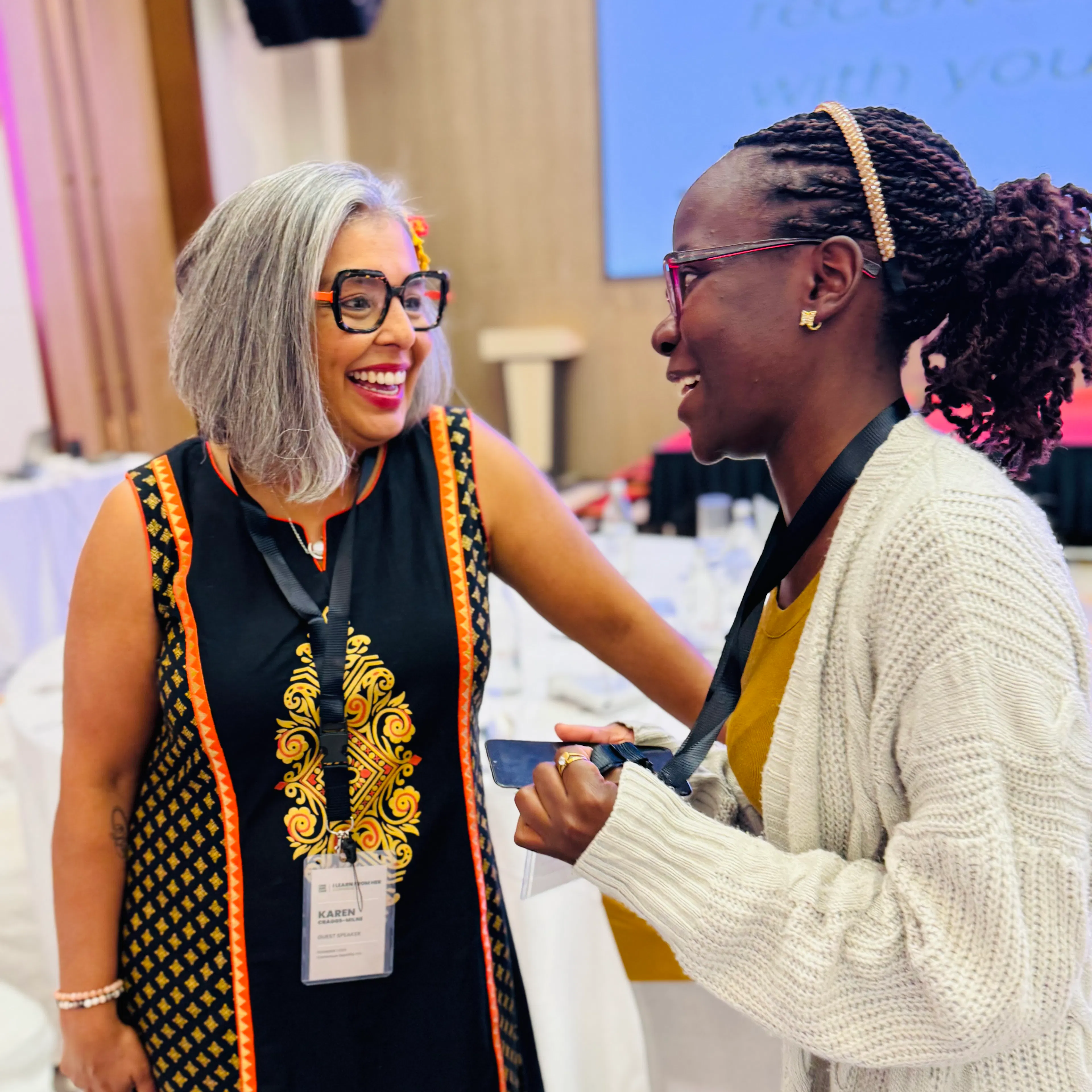 A One Girl Can mentor and her mentee talking and laughing together at a conference