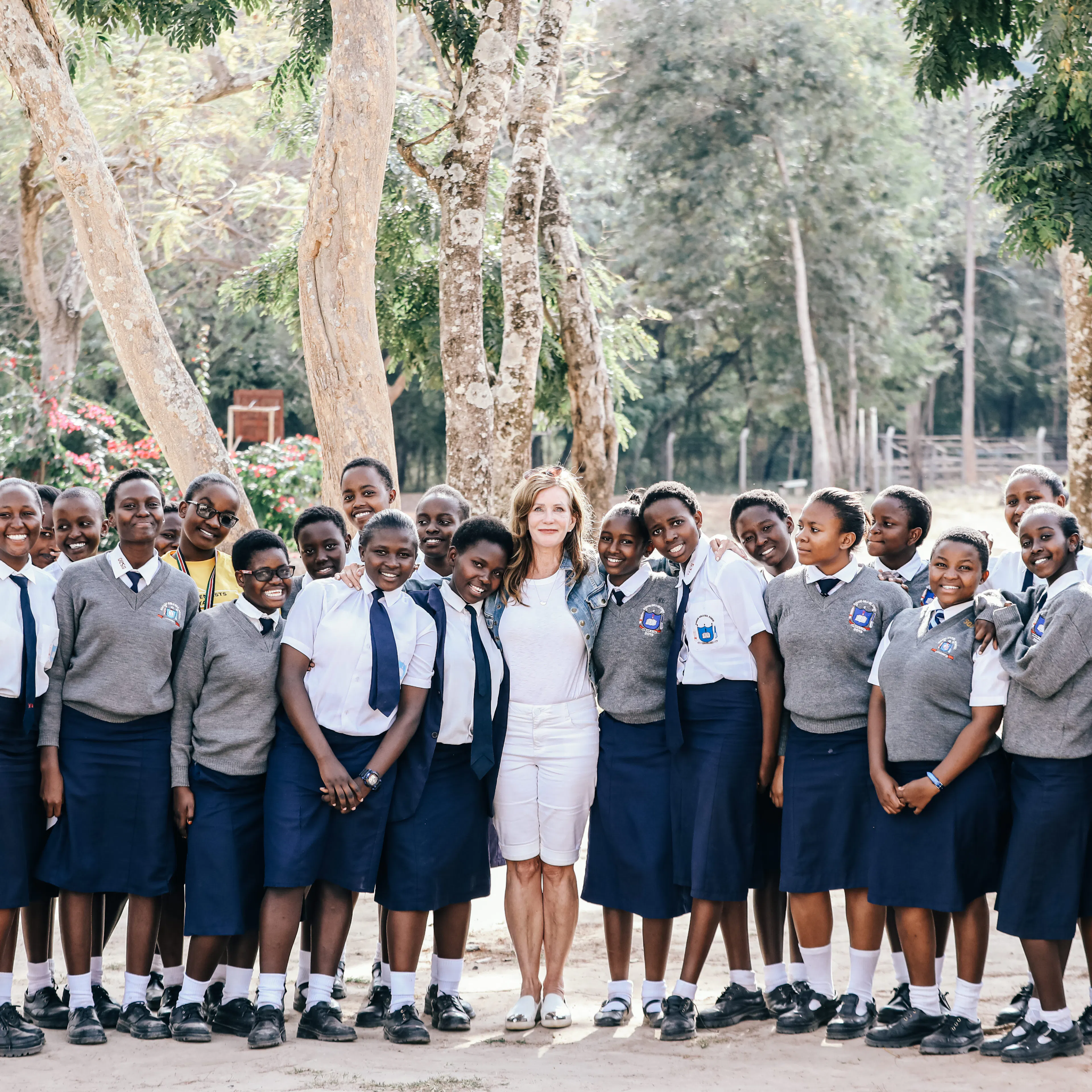 One Girl Can founder Lotte Davis standing with a large group of scholarship students