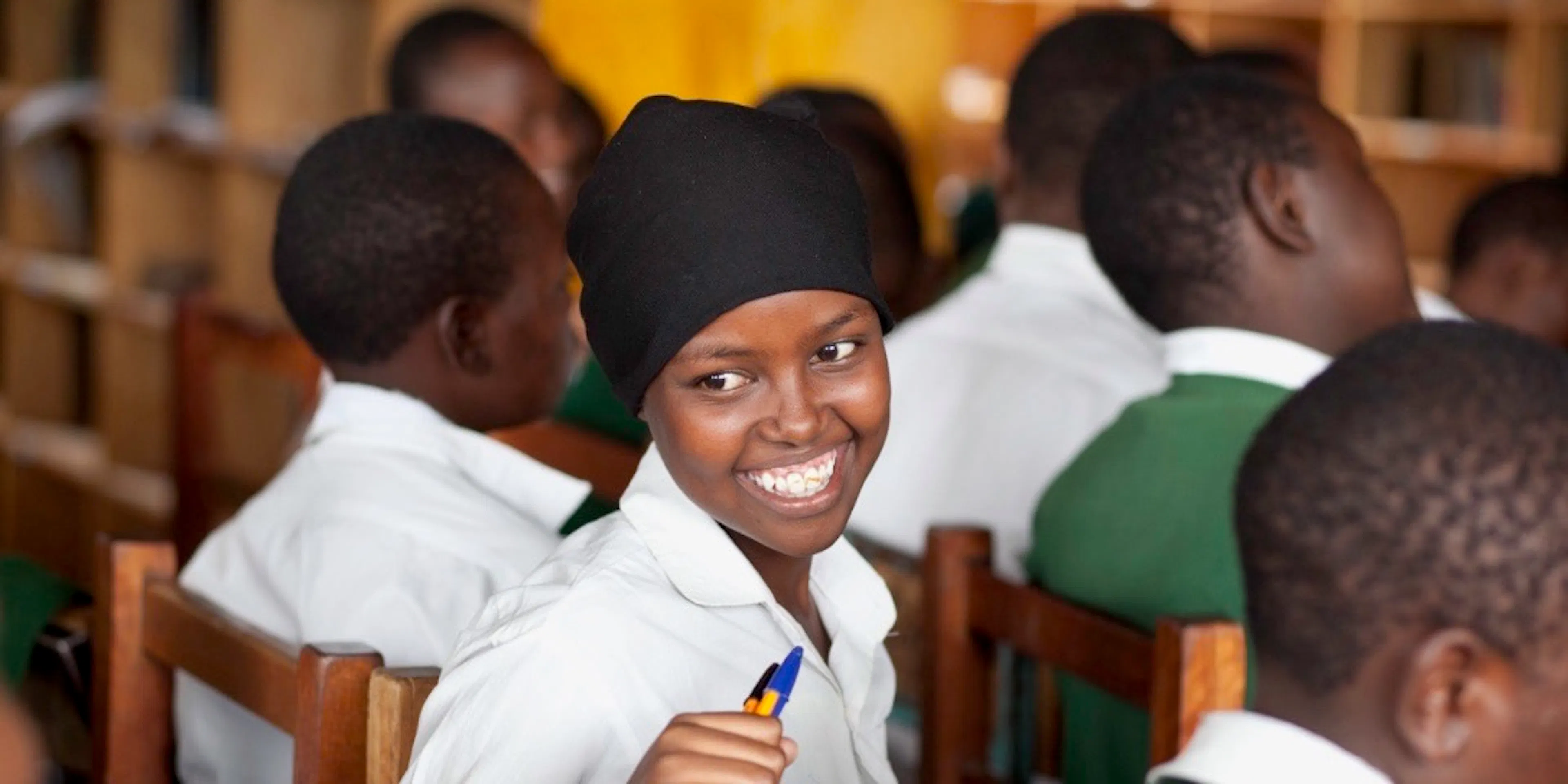 Student smiling over her shoulder during class in Kenya