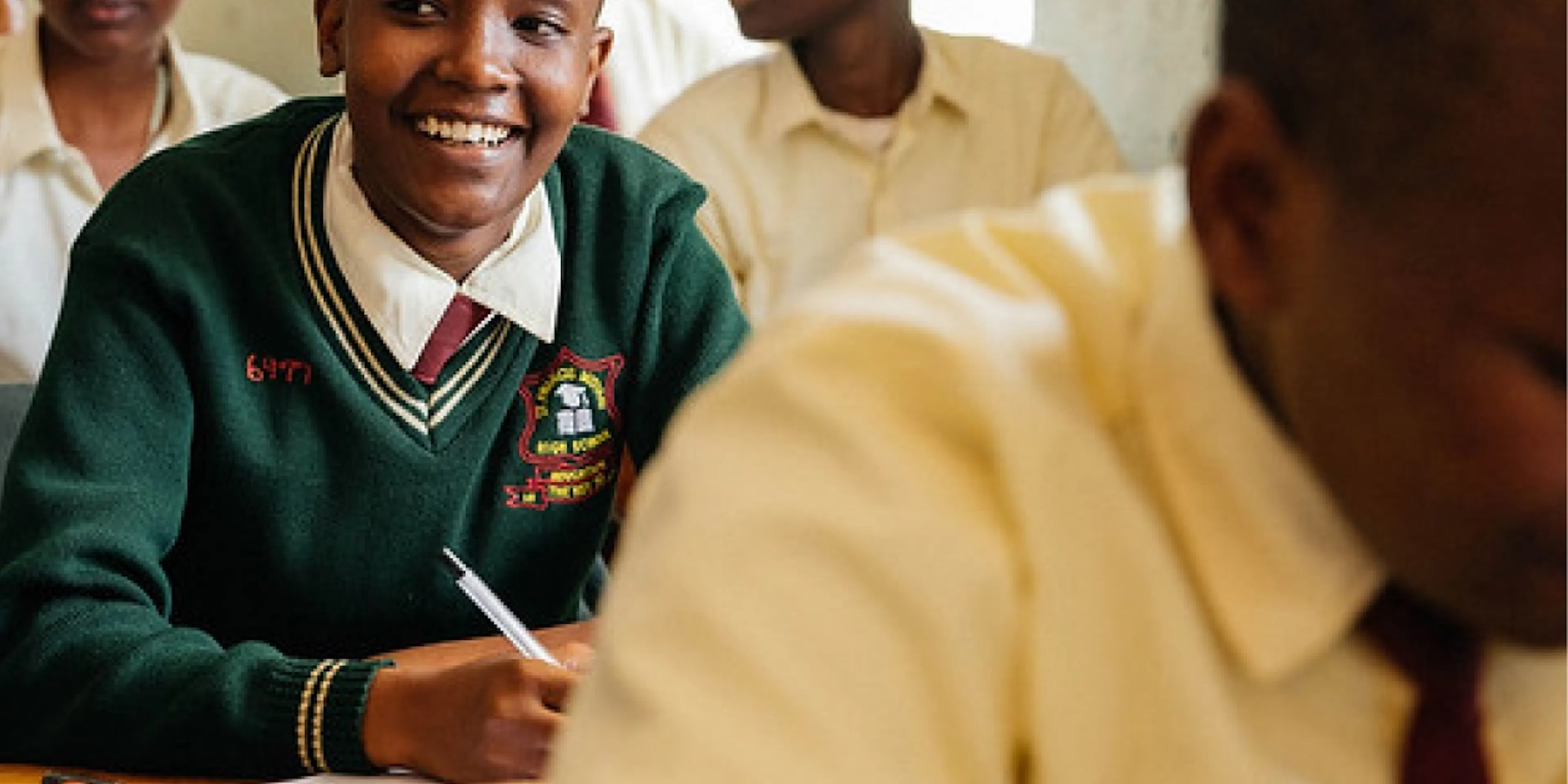 Student smiling at her desk during class in Kenya