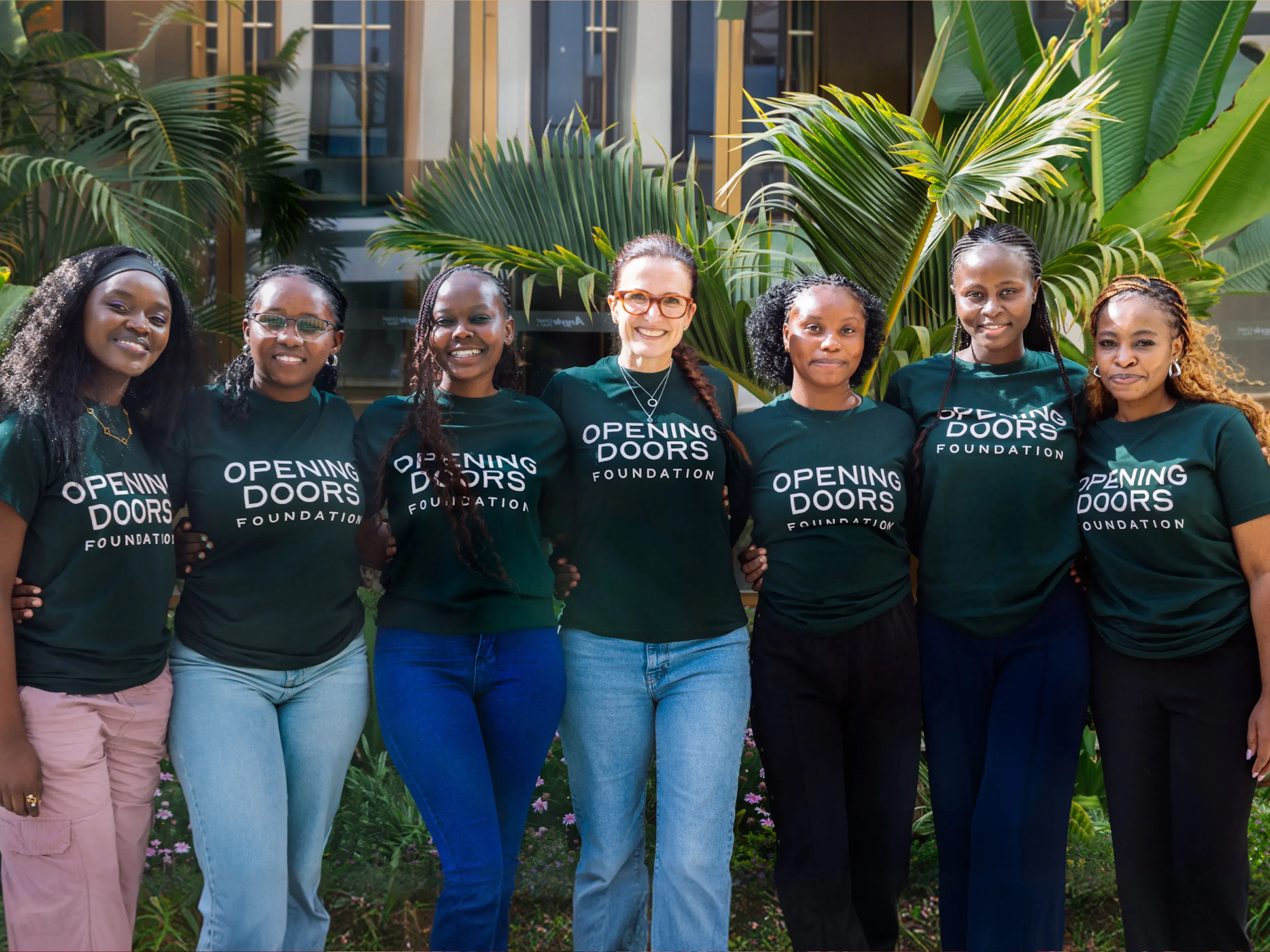 Seven mentors and graduates in Opening Doors Foundation t-shirts standing together