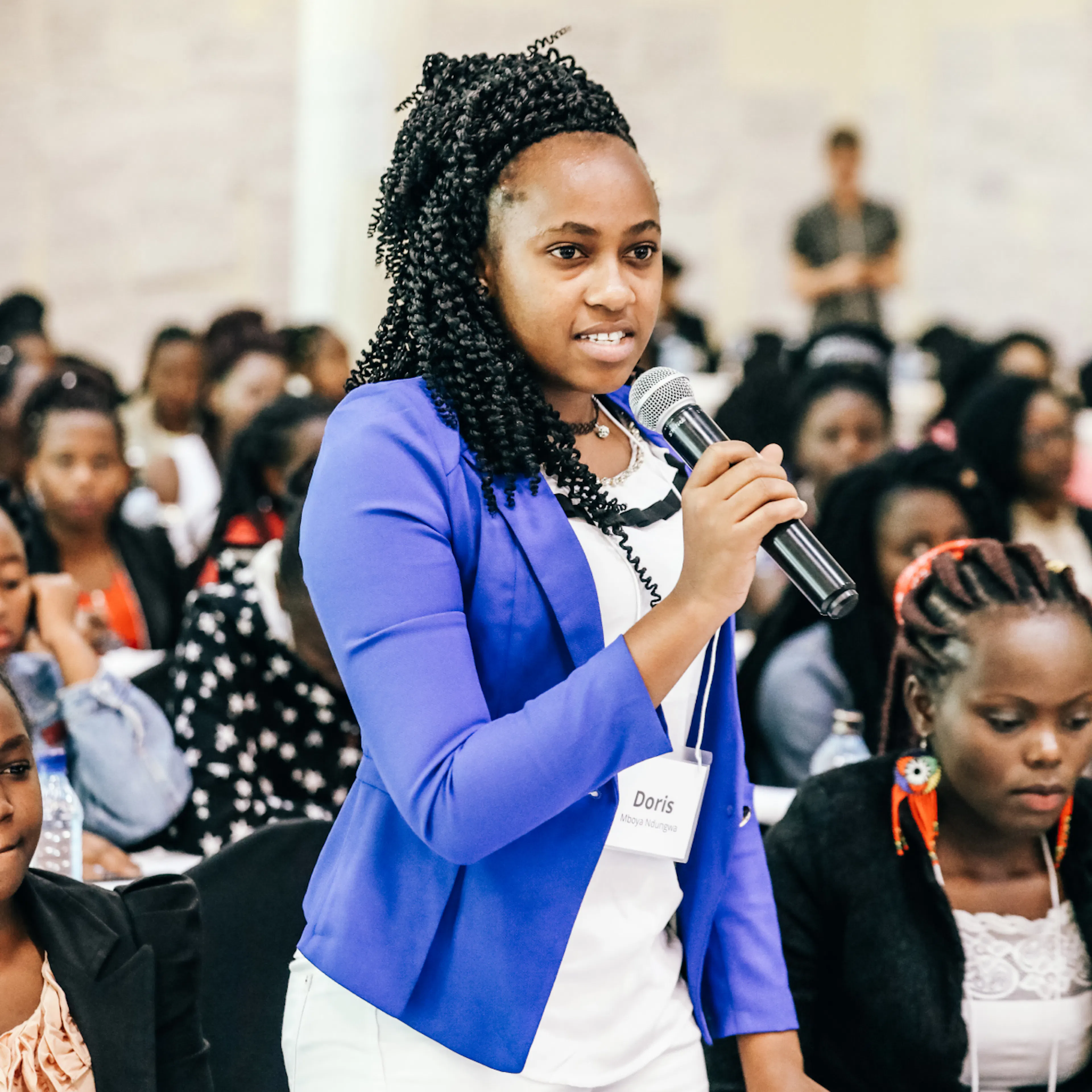 A student speaking into a microphone in front of an audience at the leadership conference