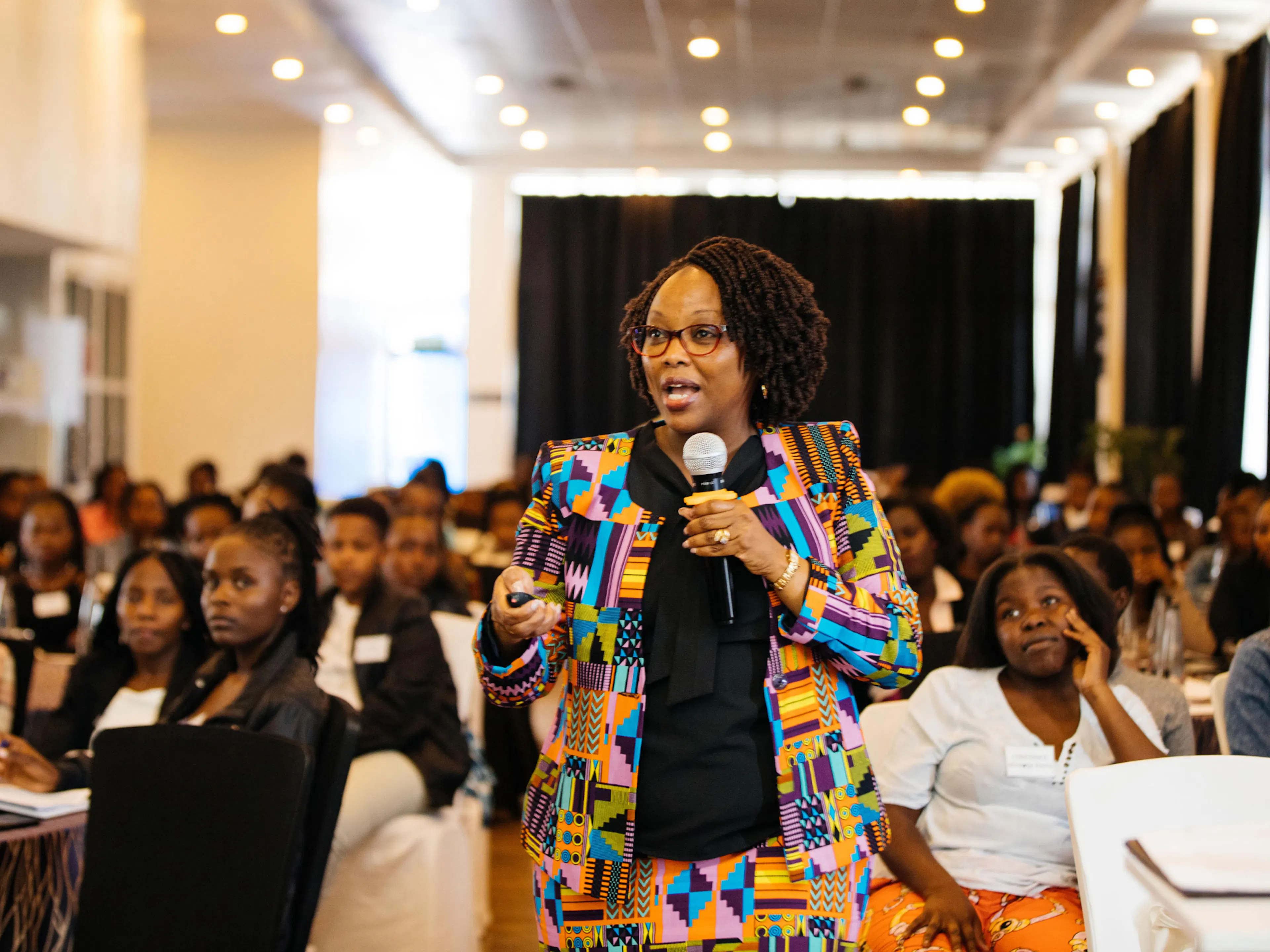 A speaker addressing a room of One Girl Can students at a training session