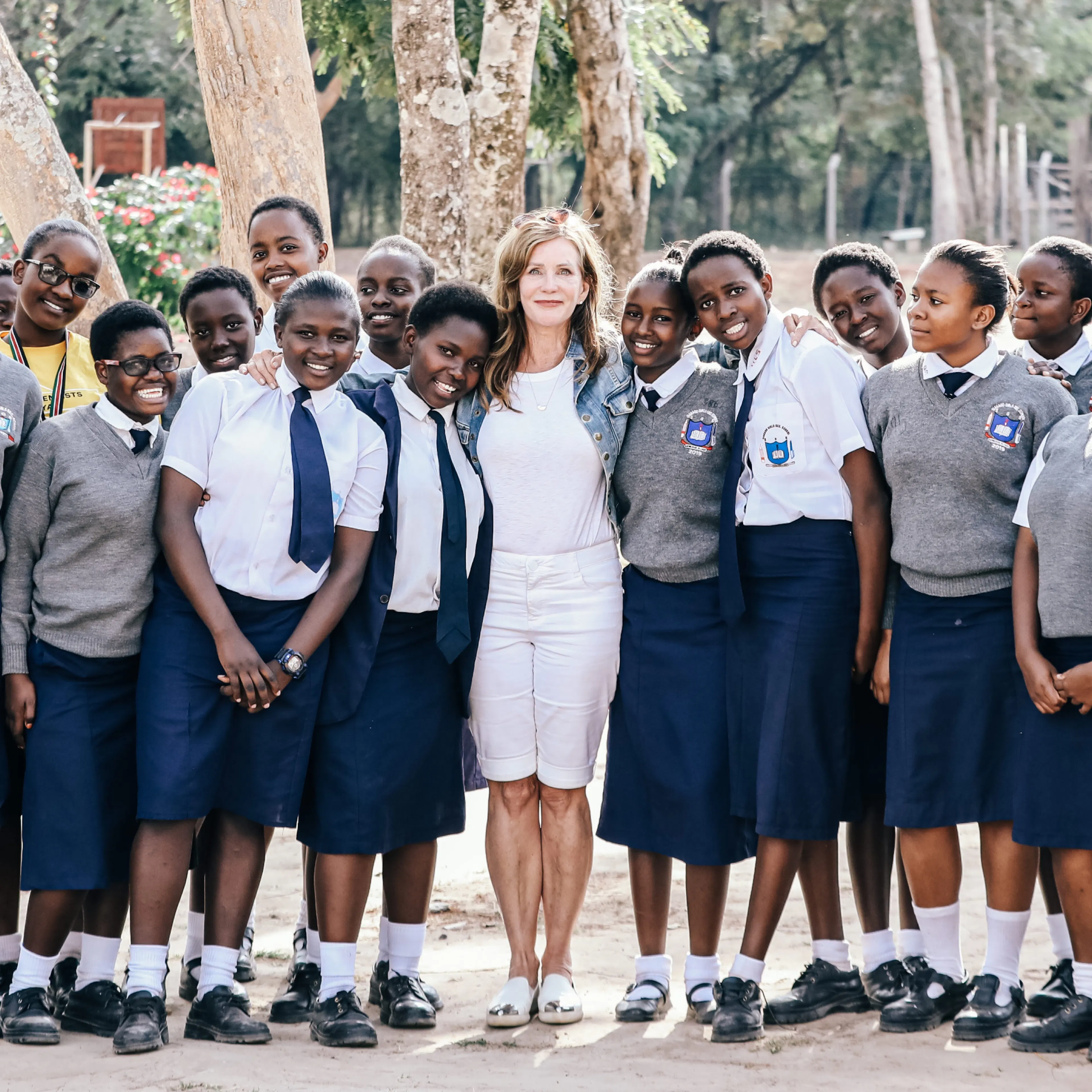 One Girl Can founder Lotte Davis standing with a group of students in Kenya