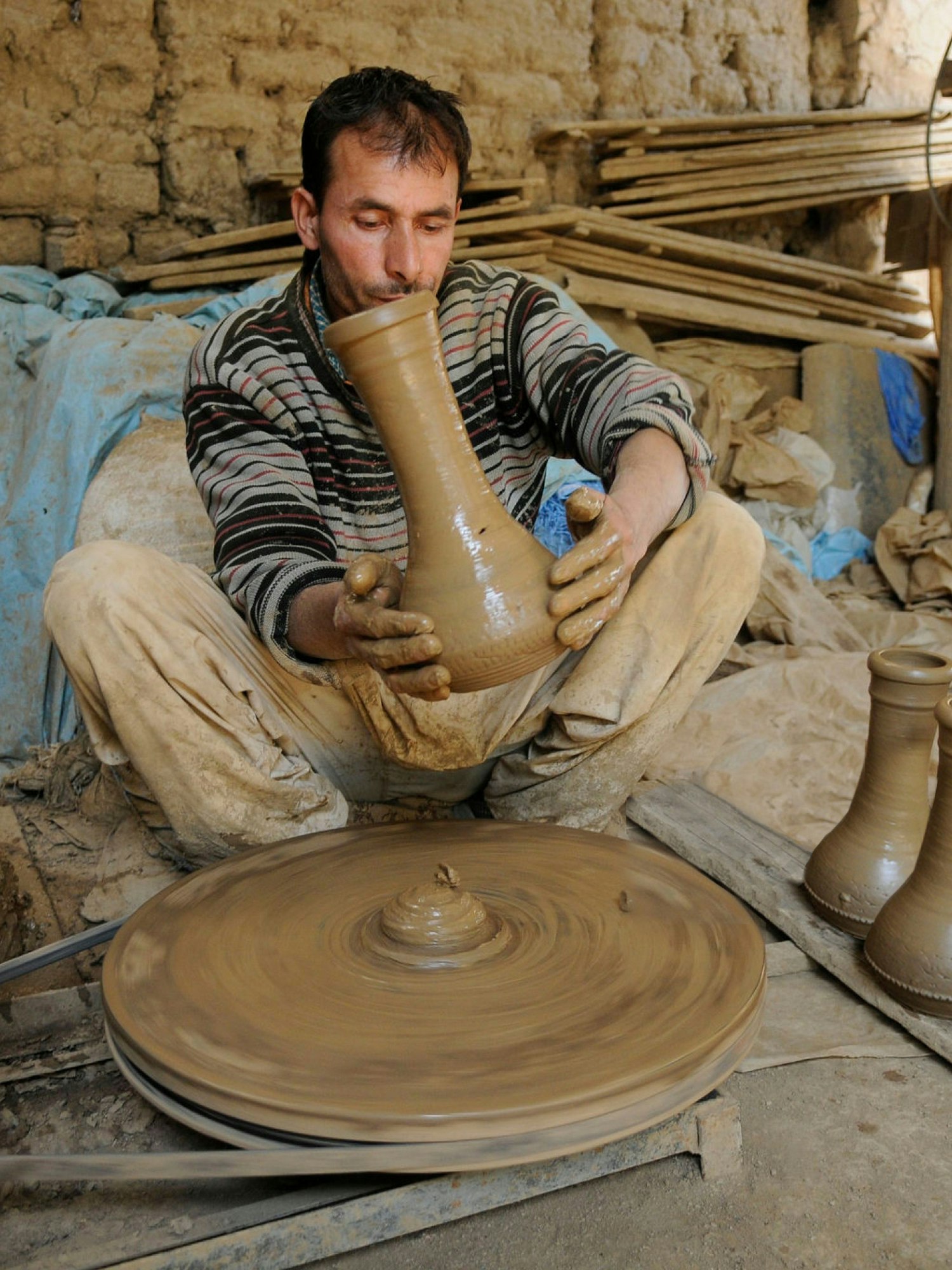 A photograph of a man making a pot.