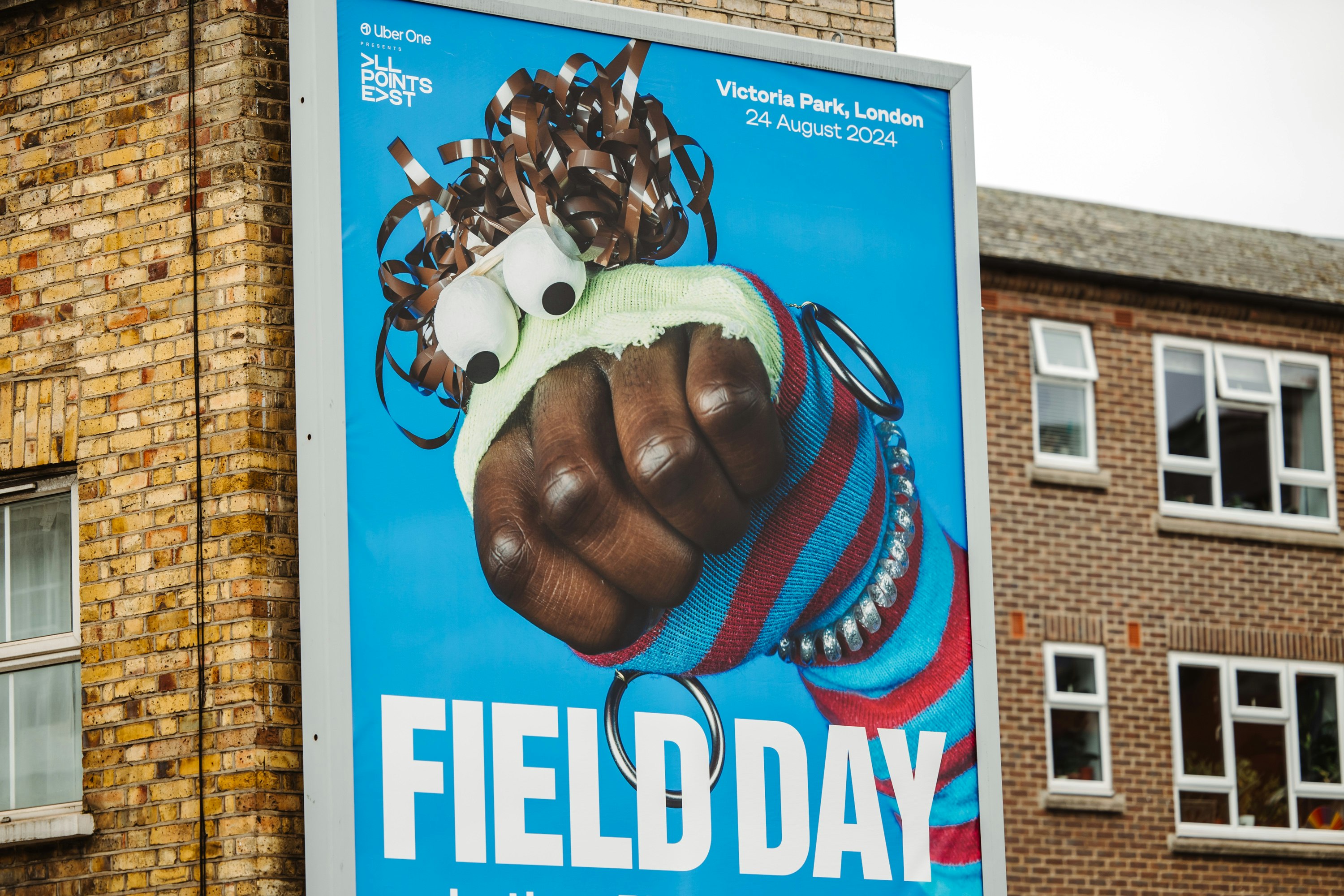 A large billboard advertising Field Day, featuring a stripy puppet on a blue background.