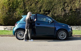 A photograph of a woman getting into a Fiat 500 Electric Icon 