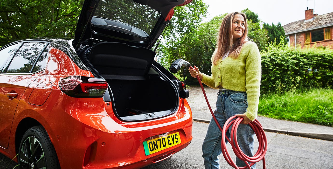 Smiling woman holding an electric charger