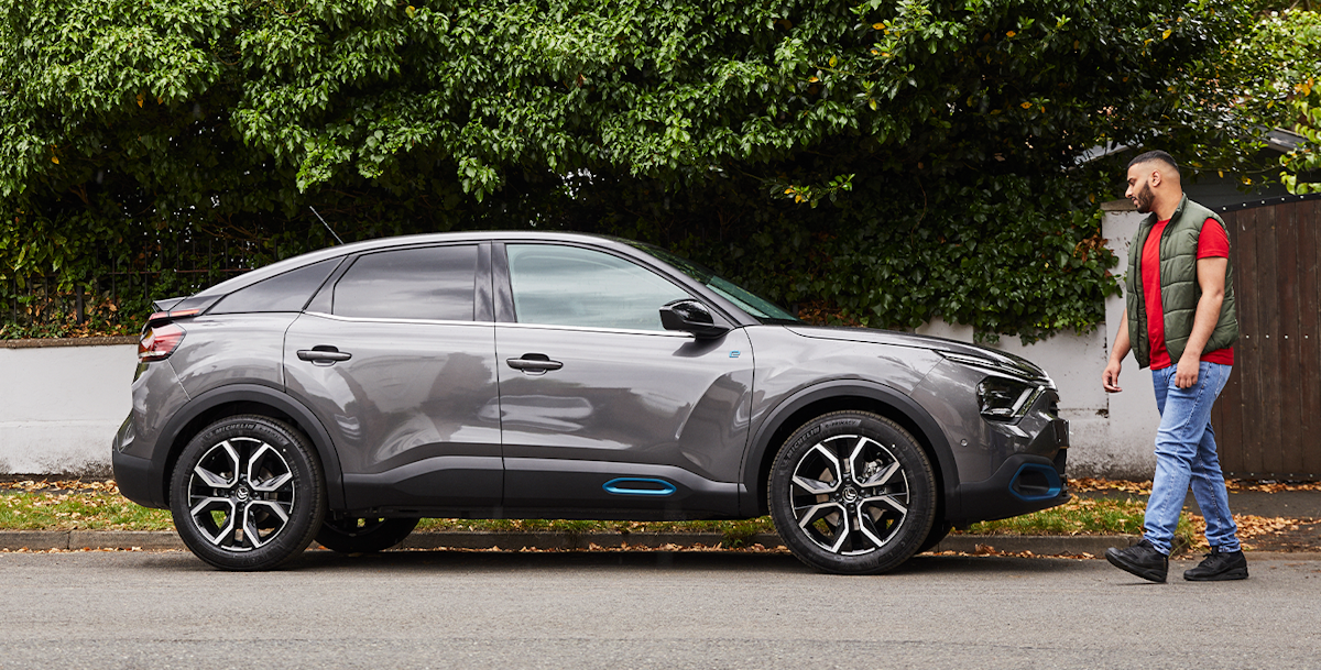 Man walking next to a silver Citroen EC4 C series