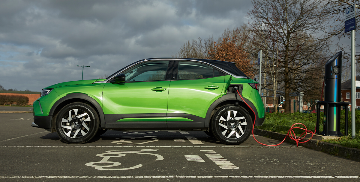 A green Mokka e plugged into an electric charger
