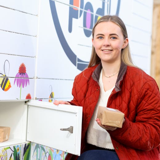 Girl taking parcel from OOHPod locker in Jonesborough