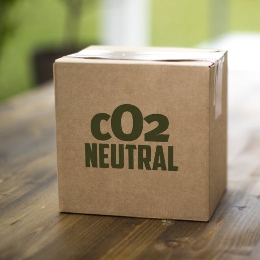 A carbon neutral parcel box sits on its own on a wooden bench