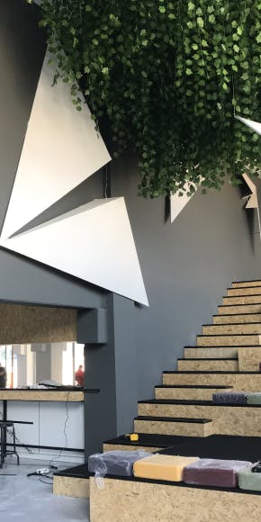 OPLOG office interior with modern geometric wall design stairs and hanging plants
