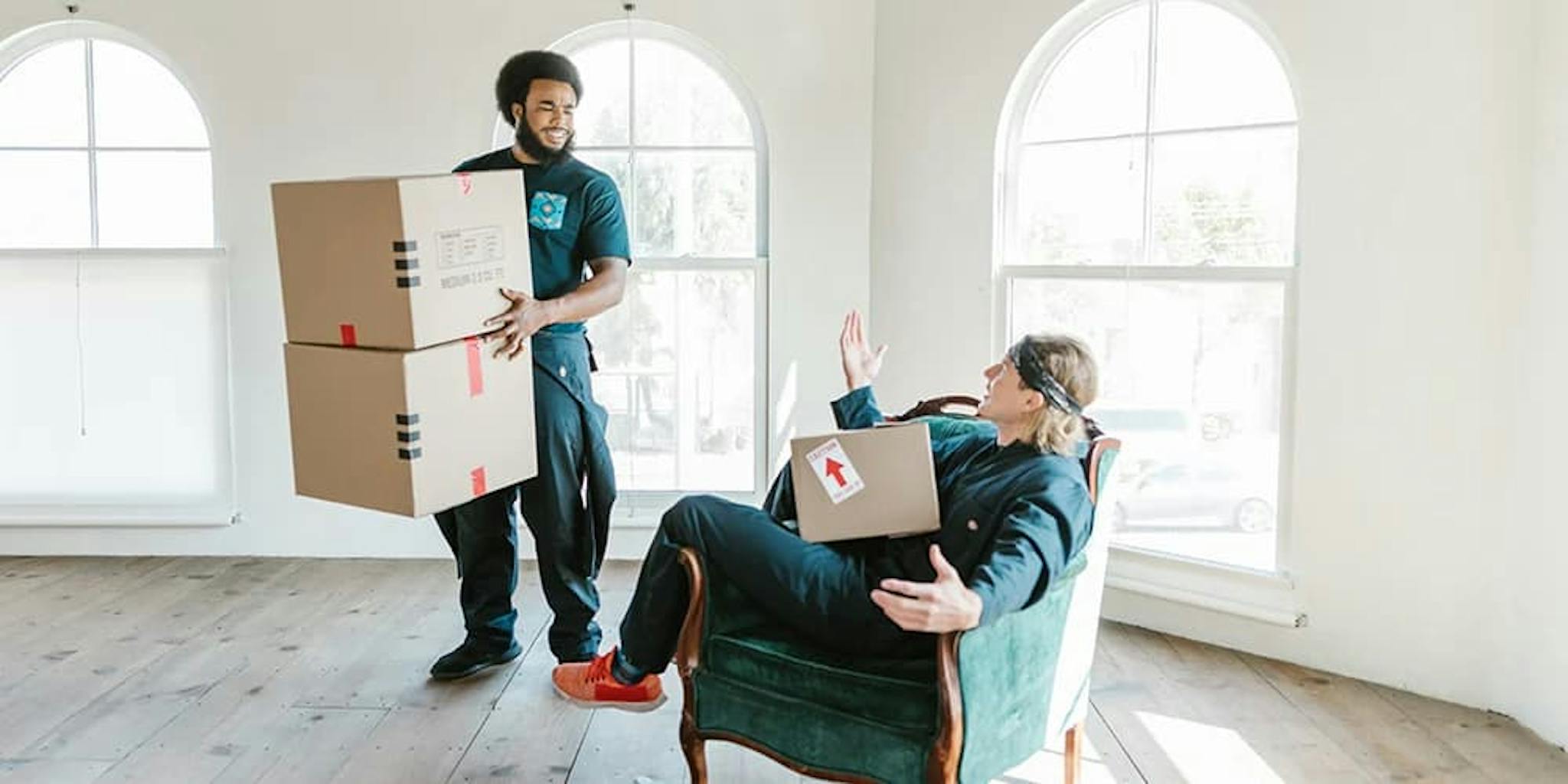 Kargo kutularını taşıyan iki kişi