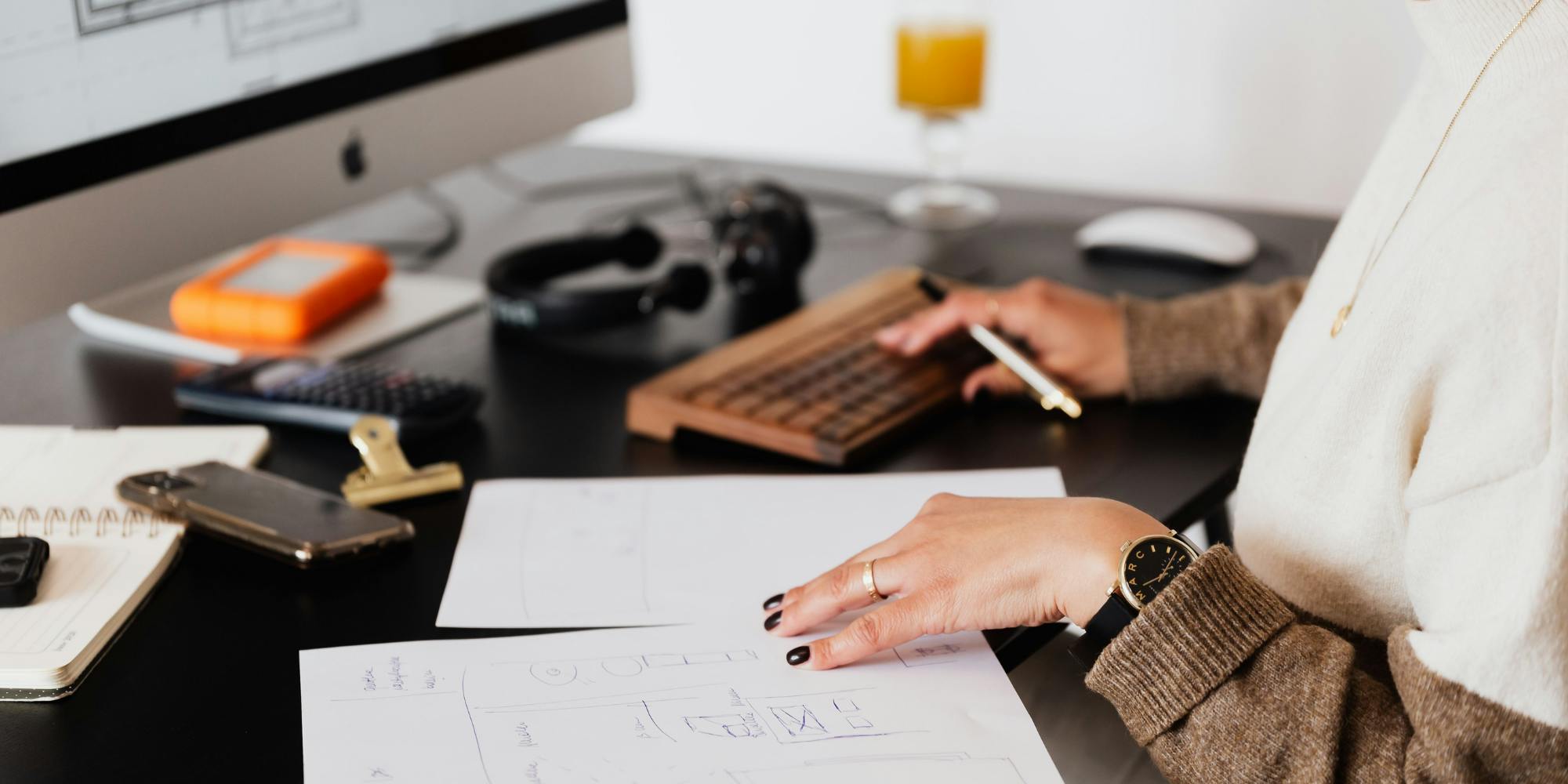 woman checking papers and writing on keyboard