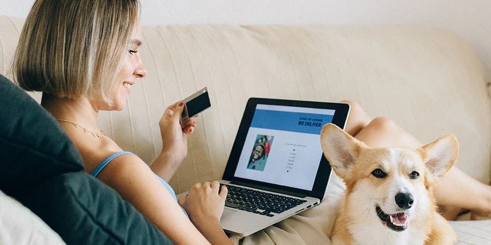 Laptop ile alışveriş yapan kadın ve köpek