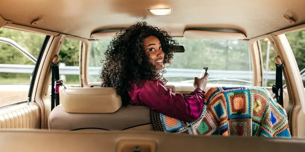 Araba içerisinde yolculuk yaparken arkasına bakan kadın