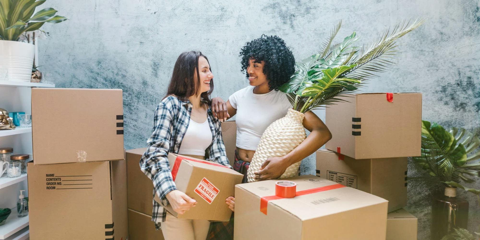 two woman standing between boxes