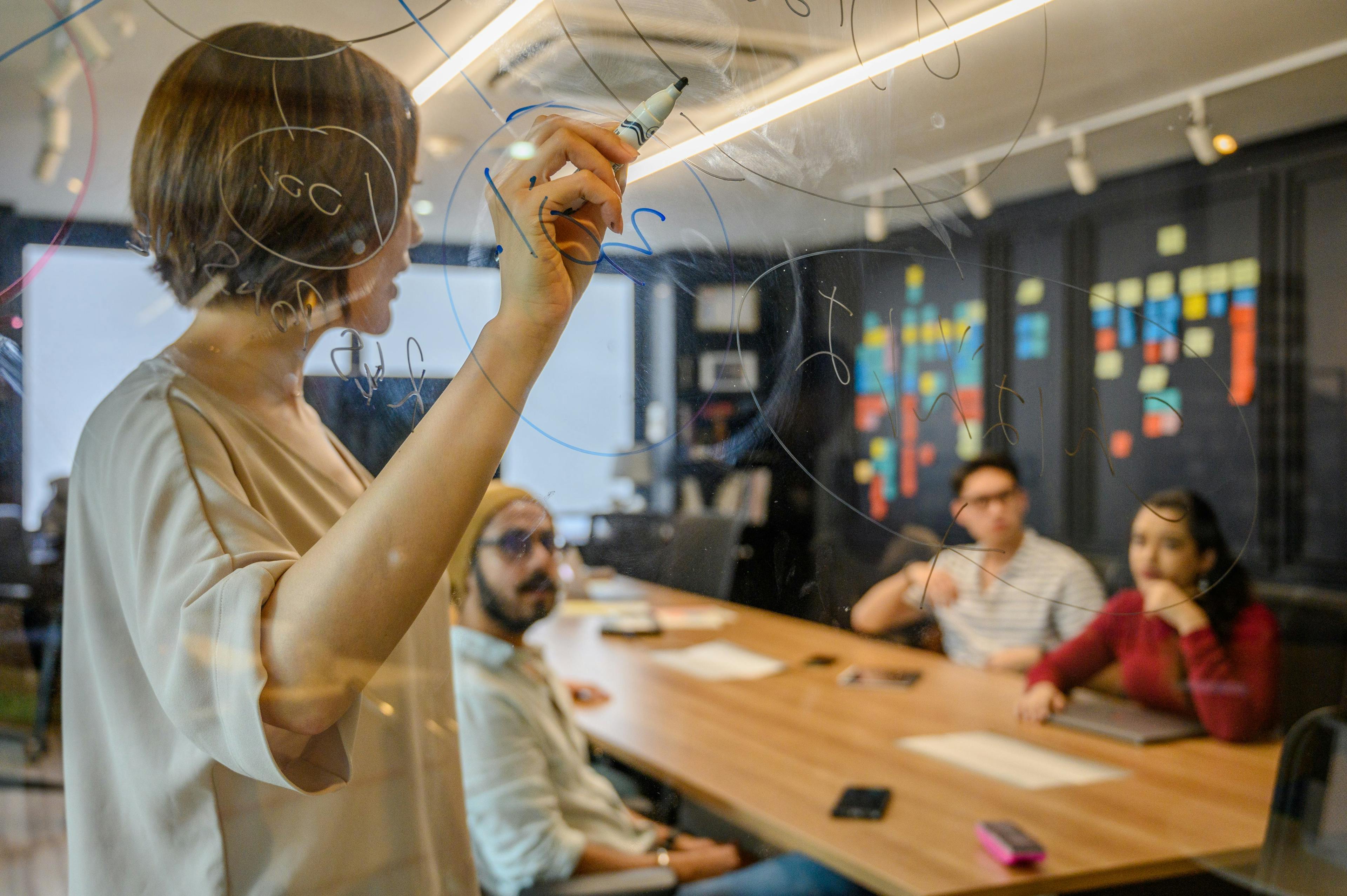 Woman drawing on glass wall with marker