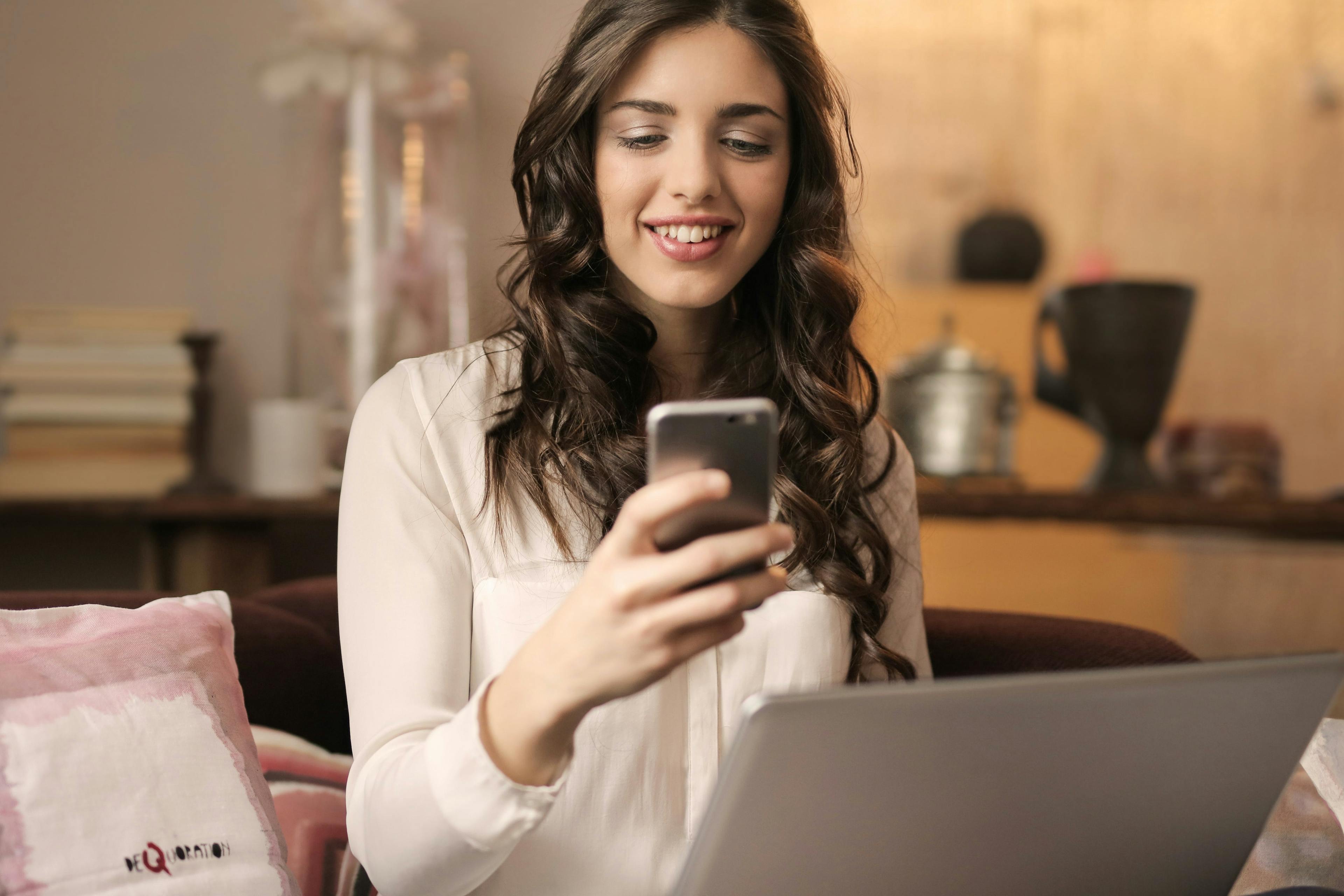 a girl laughing and looking at her phone