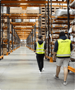 two warehouse workers walking inside a warehouse