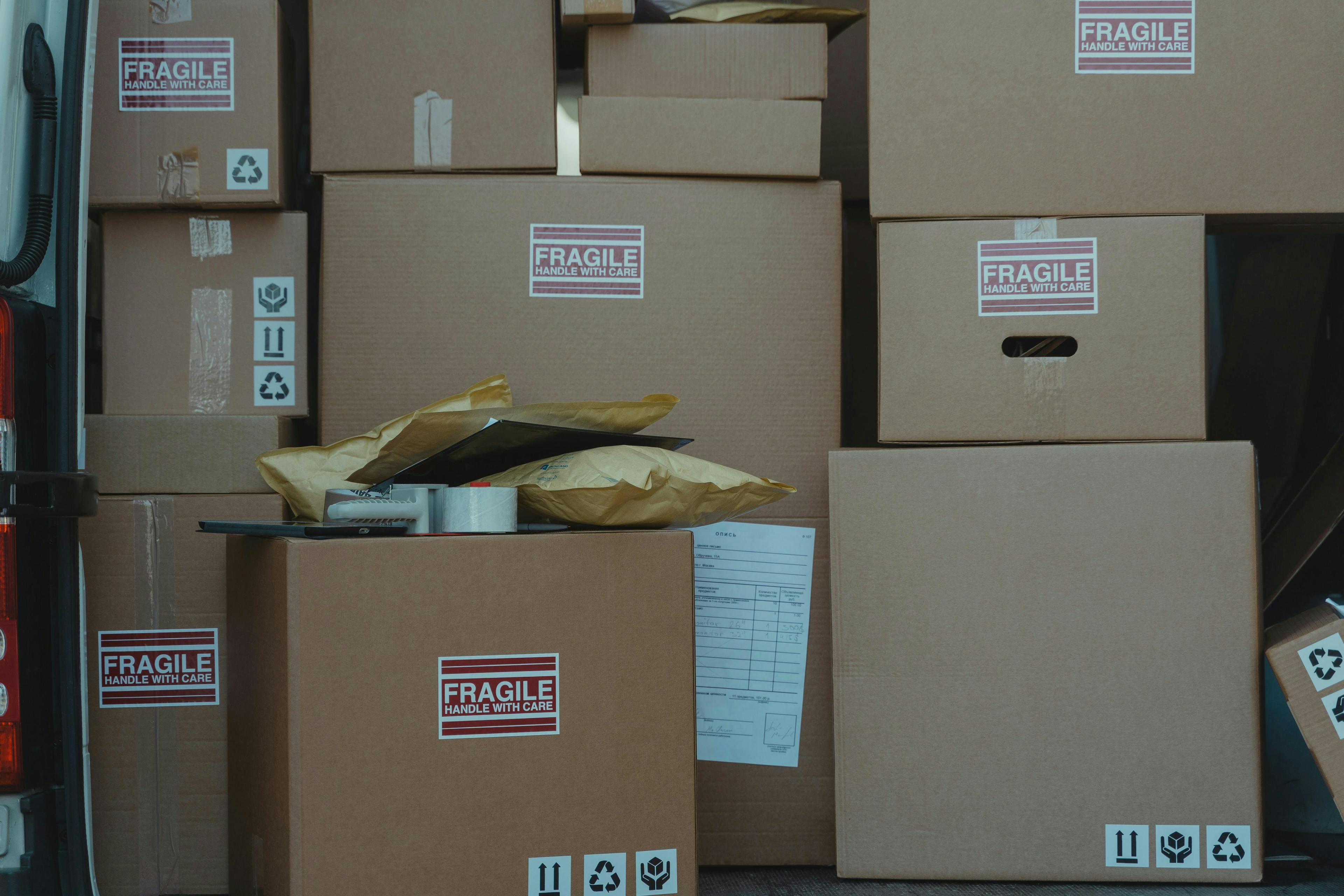 Stacked cardboard boxes with fragile warning labels and shipping symbols