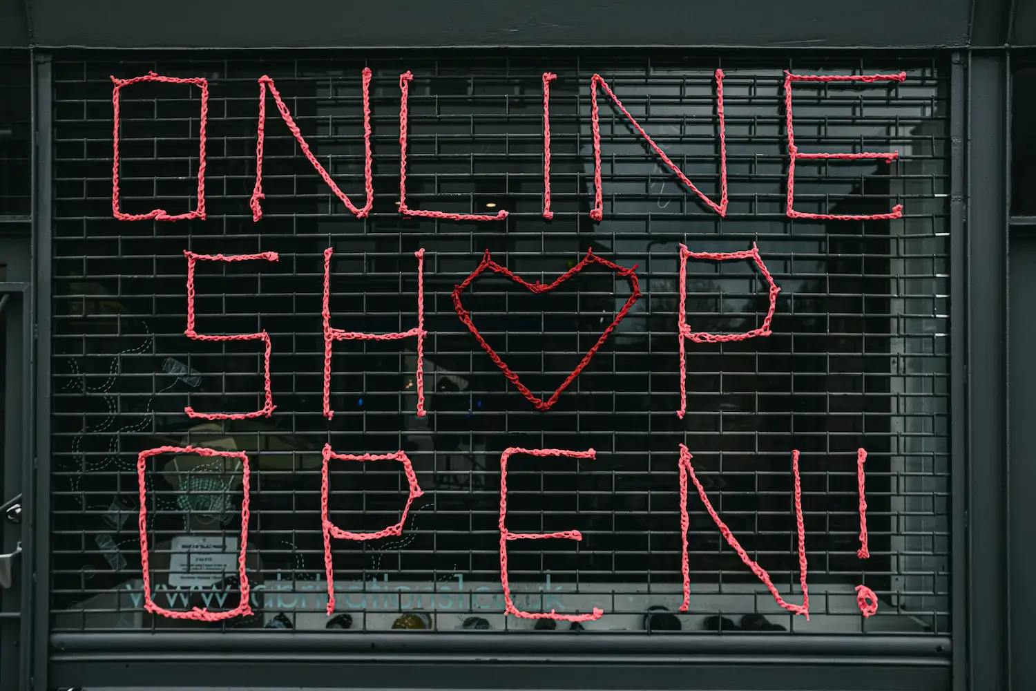 Açılır kepengin önünde kırmızı harflerle "Online Mağaza Açık!" yazısı.