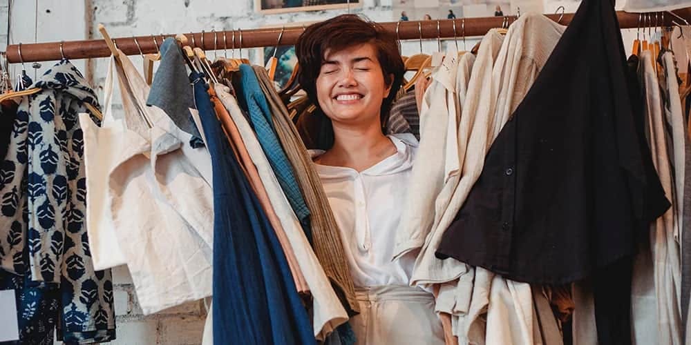 Kıyafetler arasında güleryüzlü kadın